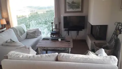 a living room with a white couch and a tv at Viña Santa Petronila Torre in Jerez de la Frontera