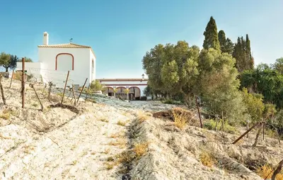 a white building on top of a hill with trees at Viña Santa Petronila Torre in Jerez de la Frontera