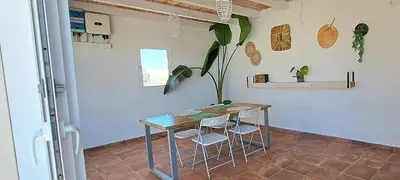 a table and chairs in a room with a plant at Alojamiento Mise in Conil de la Frontera