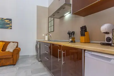 a kitchen with a counter and a couch in a room at Apartamento Centro con Parking Privado in El Puerto de Santa María
