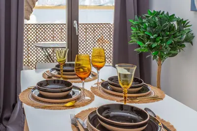 a table with plates and wine glasses on it at Apartamento Centro con Parking Privado in El Puerto de Santa María