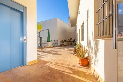 a courtyard of a building with a blue door and a plant at Apartamento Centro con Parking Privado in El Puerto de Santa María