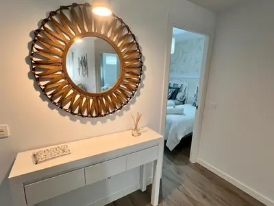 a mirror on a wall above a dresser in a room at Jardines del Porvenir 4 in Puerto Real