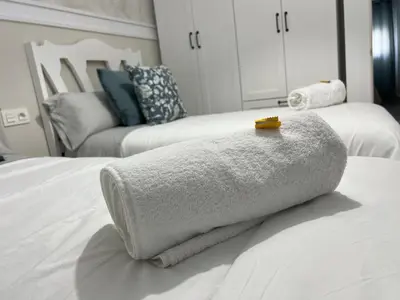 a pile of towels sitting on top of a bed at Jardines del Porvenir 4 in Puerto Real