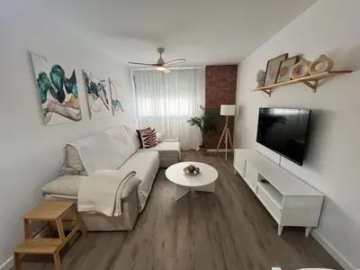 a living room with a couch and a tv at Jardines del Porvenir 4 in Puerto Real