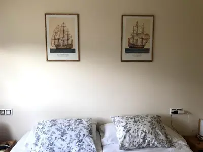 two pictures of ships on the wall above a bed at Vacaciones de lujo GOLF-PLAYA. Costa Ballena-Cádiz in Rota