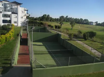 a tennis court in front of a building at Vacaciones de lujo GOLF-PLAYA. Costa Ballena-Cádiz in Rota