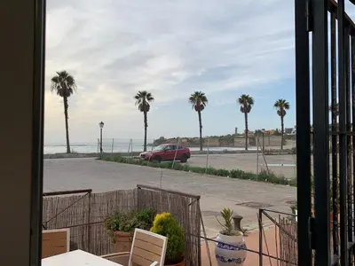 a room with a view of the ocean and palm trees at Apartamento La Vasca in El Puerto de Santa María