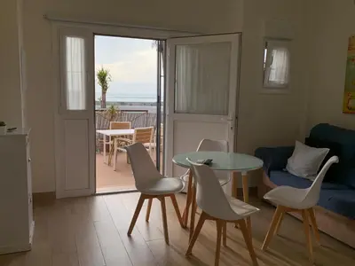 a living room with a table and chairs and a balcony at Apartamento La Vasca in El Puerto de Santa María