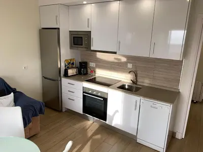 a kitchen with white cabinets and a sink and a refrigerator at Apartamento La Vasca in El Puerto de Santa María
