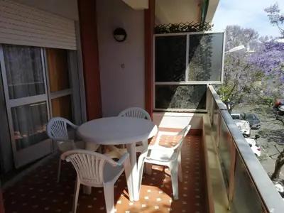 a balcony with a table and chairs and windows at ENTRE SAL Y ARENA in Cádiz