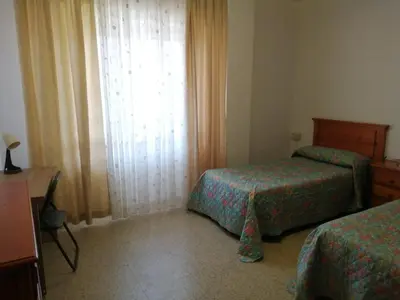 a hotel room with two beds and a window at ENTRE SAL Y ARENA in Cádiz