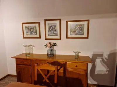 a wooden desk with a vase of flowers on it at ENTRE SAL Y ARENA in Cádiz