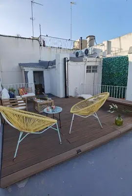 a patio with two chairs and a table on a deck at Fantástico piso nuevo, Mentidero in Cádiz