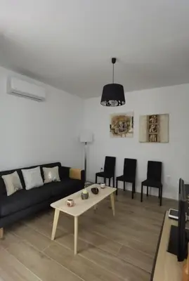a living room with a black couch and a table at Fantástico piso nuevo, Mentidero in Cádiz