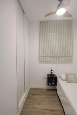 a white bedroom with a bed and a ceiling fan at Fantástico piso nuevo, Mentidero in Cádiz