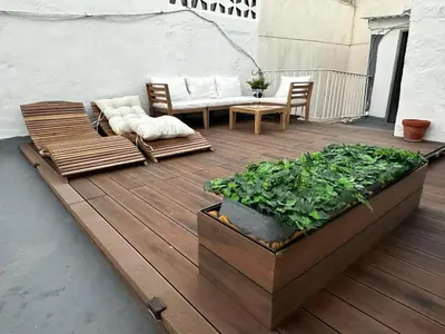 a wooden deck with a couch and a table and chairs at Fantástico piso nuevo, Mentidero in Cádiz