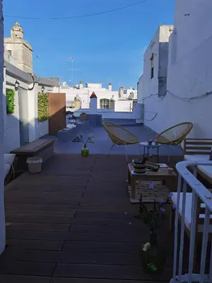 a patio with two chairs and a table on a building at Fantástico piso nuevo, Mentidero in Cádiz
