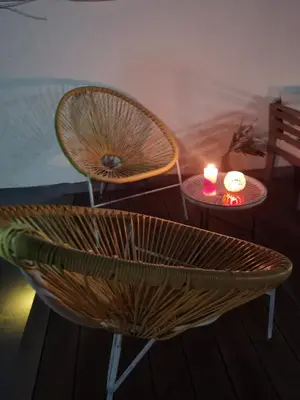 a wicker chair and two tables with two candles at Fantástico piso nuevo, Mentidero in Cádiz