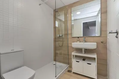 a bathroom with a toilet and a sink and a shower at Acogedora vivienda Costa Ballena in Chipiona