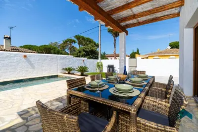 a patio with a table and chairs and a swimming pool at VILLA SUR in Chiclana de la Frontera