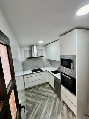 a kitchen with white cabinets and a stove top oven at Piso céntrico y tranquilo con garaje incluido in Sanlúcar de Barrameda