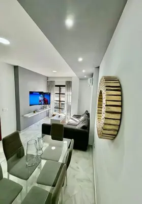 a living room with a table and a couch at Piso céntrico y tranquilo con garaje incluido in Sanlúcar de Barrameda