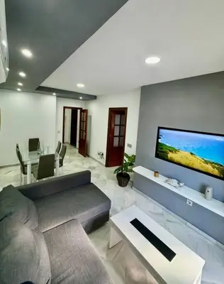 a living room with a couch and a flat screen tv at Piso céntrico y tranquilo con garaje incluido in Sanlúcar de Barrameda