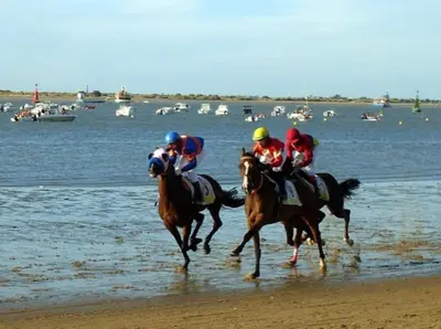 a group of jockeys riding horses on the beach at Piso céntrico y tranquilo con garaje incluido in Sanlúcar de Barrameda