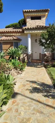 a home with a walkway leading to a garage at Beach house near Tennis Club La Barrosa in Chiclana de la Frontera