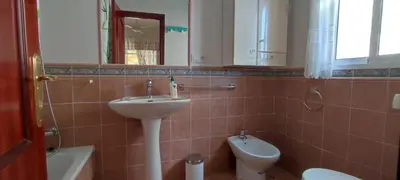 a bathroom with a sink and a toilet and a mirror at Beach house near Tennis Club La Barrosa in Chiclana de la Frontera