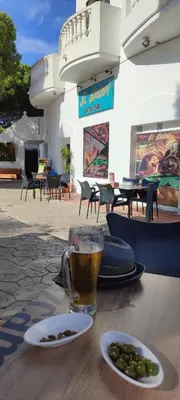 a cup of beer and a plate of olives on a table at Beach house near Tennis Club La Barrosa in Chiclana de la Frontera