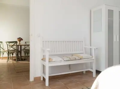 a white bench in a room with a table at Apartoyou - Río Guadalete in El Puerto de Santa María