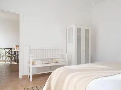 a white bedroom with a bed and a white cabinet at Apartoyou - Río Guadalete in El Puerto de Santa María