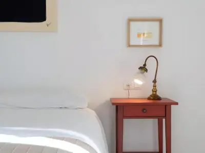 a bedroom with a bed and a table with a lamp at Apartoyou - Río Guadalete in El Puerto de Santa María
