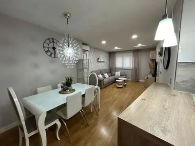 a dining room and living room with a table and chairs at Villa Malena in Chiclana de la Frontera
