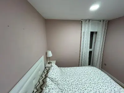 a small bedroom with a bed and a window at Villa Malena in Chiclana de la Frontera