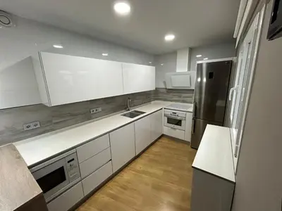 a kitchen with white cabinets and stainless steel appliances at Villa Malena in Chiclana de la Frontera
