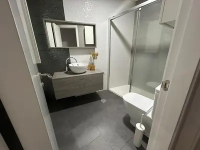 a bathroom with a toilet and a sink and a shower at Villa Malena in Chiclana de la Frontera