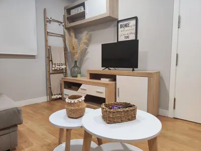 a living room with a table and a tv at Villa Malena in Chiclana de la Frontera