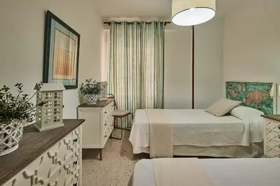 a hotel room with two beds and a dresser at Paso del Mar Ha Apartment in Cádiz