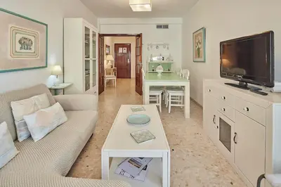 a living room with a couch and a tv at Paso del Mar Ha Apartment in Cádiz