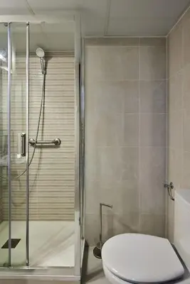 a bathroom with a toilet and a glass shower at Paso del Mar Ha Apartment in Cádiz