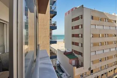 a view of the beach from the balcony of a building at Paso del Mar Ha Apartment in Cádiz