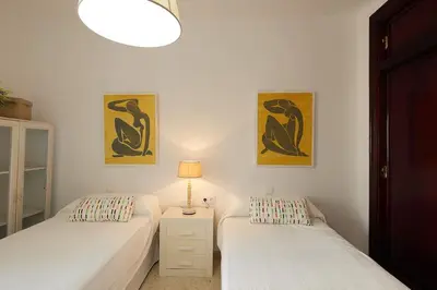 a bedroom with two beds and a lamp on a night stand at Paso del Mar Ha Apartment in Cádiz