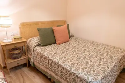 a bedroom with a bed and a table with a lamp at Apartamento Chanca - Ole Solutions in El Puerto de Santa María
