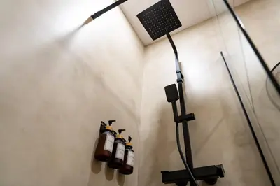 a room with a shower with a microphone and a wall at Apartamento Chanca - Ole Solutions in El Puerto de Santa María