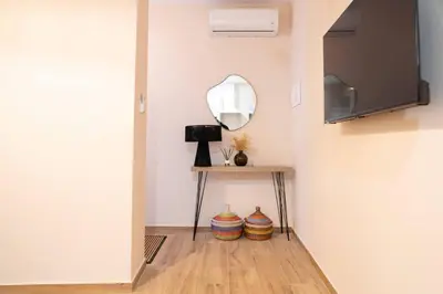 a hallway with a mirror and a table with vases at Apartamento Chanca - Ole Solutions in El Puerto de Santa María
