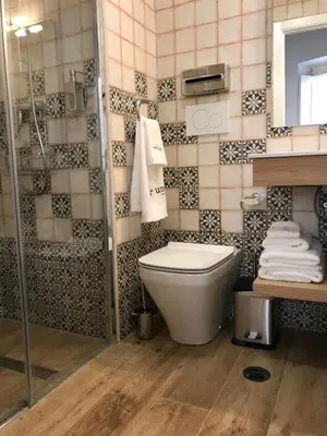 a white bedroom with a bed and a chair at Apartamentos Rosario Centro in Cádiz