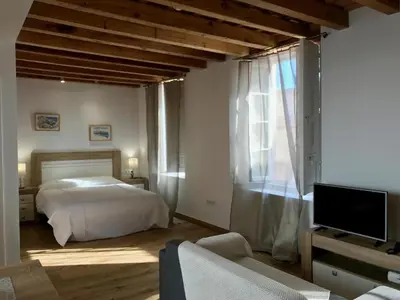 a living room with a couch and a kitchen at Apartamentos Rosario Centro in Cádiz
